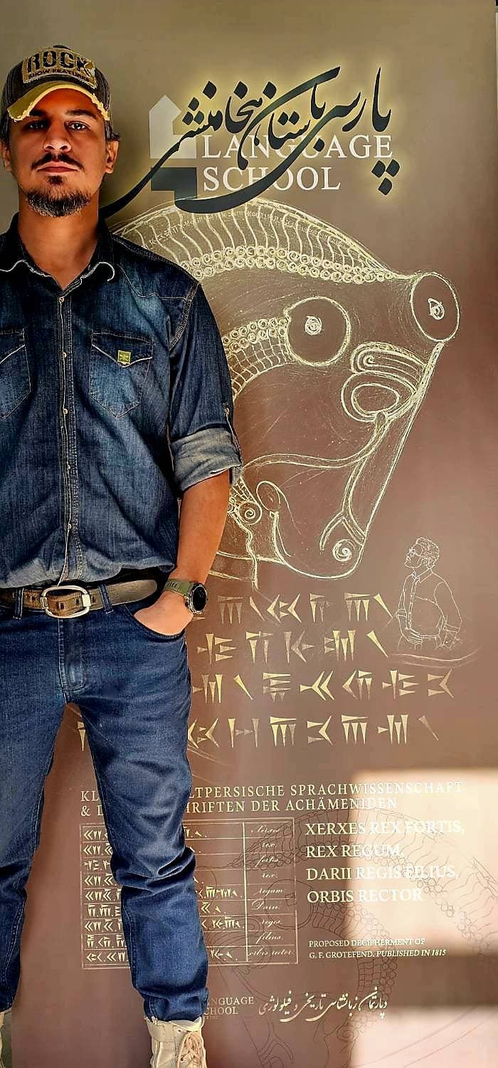 Mahdi Xeinali in front of the Language School banner